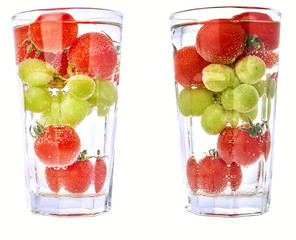 Cherry tomatos and grapes in a cocktail glas with water - isolated, two versions.
