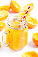 Orange juice with remains of shells in glass jar.