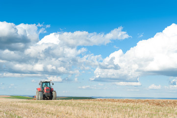 Obraz premium agricultural machinery working the land in the field.