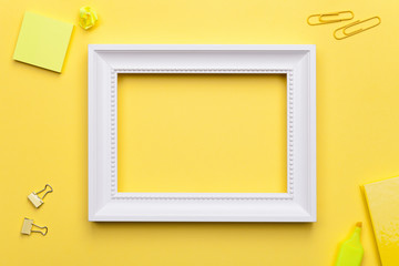 White Frame with Office Accessories on Yellow Background