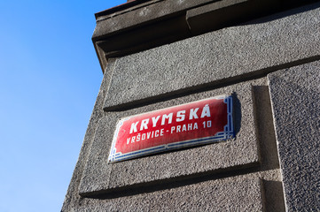 Naklejka premium Krymska street, Vrsovice district, Prague city, Czech Republic / Czechia - street name sign on the wall. Place is popular and famous among tourists and locals
