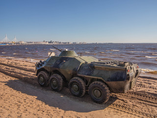 Armored personnel carrier on sand against the blue sky