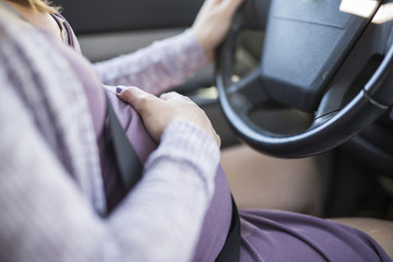 pregnant woman driving a car buttoned up belt