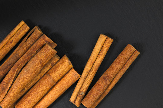 Cinnamon sticks on black slate plate