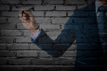 double exposure of businessman in suit pointing cement wall.