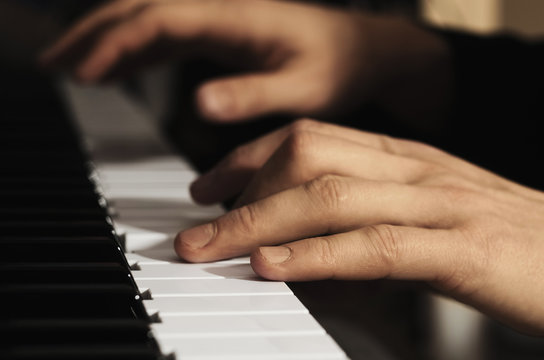 Man's hands playing the piano