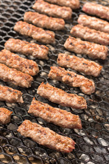 Grilling minced meat kebabs on the barbecue with selective focus