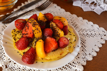 Sweet homemade pancakes with apricots, strawberries and chocolate. 