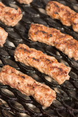 Grilling minced meat kebabs on the barbecue with selective focus