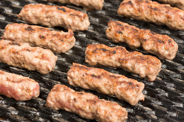 Grilling minced meat kebabs on the barbecue with selective focus