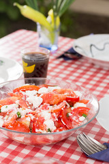 Salad with tomatoes onions and cheese served on the table