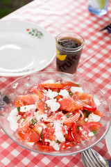 Salad with tomatoes onions and cheese served on the table
