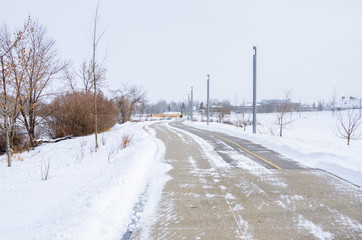 Icy Paved Riverside Path in Calgary, Canada, on a Snowy Winter Day