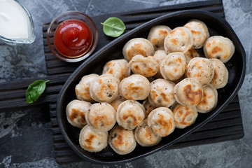 Top view of a frying pan with roasted russian pelmeni, horizontal shot
