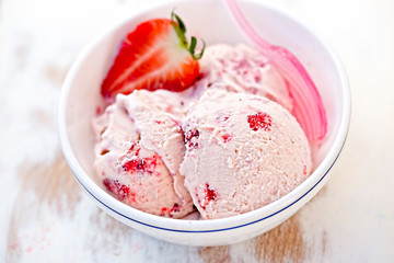 Strawberry cream ice cream in white bowl 