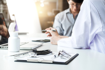 Healthcare and Medical concept, patient listening intently to a female doctor explaining patient symptoms or asking a question as they discuss paperwork together in a consultation