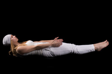 Girl doing yoga exercise in gym isolated on black.