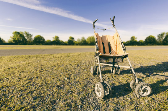 Empty Orange Baby Stroller In A Park - Missing Child Concept