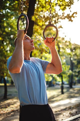 Man working out on rings in the park