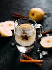 Fresh lemonade with pear lobules on a dark background