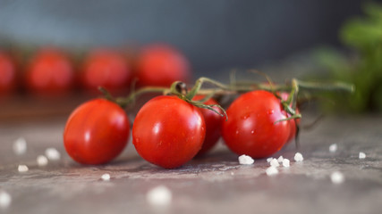 fresh cherry tomatoes branch and basil on wooden board