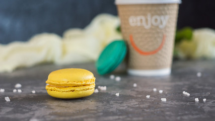 Cup of coffee to go with two colorful macaron. Morning concept