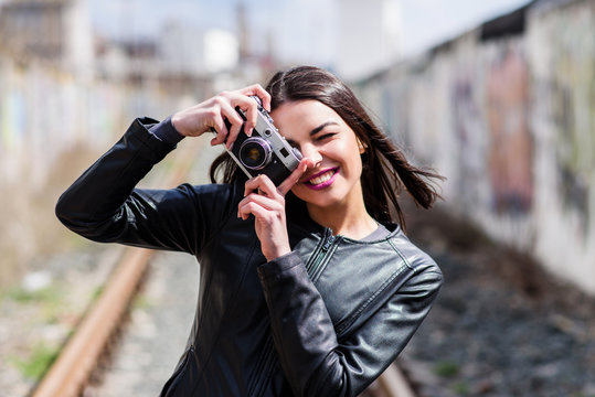 Attractive girl takes pictures with an old camera