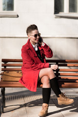 Fototapeta premium The model sits with a mobile on the bench