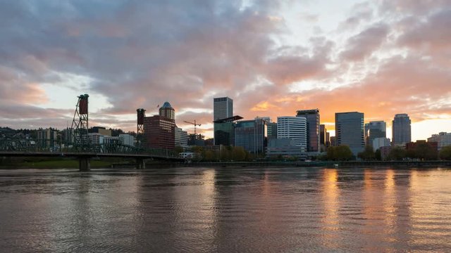 Colorful sunset and clouds over Portland Oregon downtown city skyline with Hawthorne bridge and water reflection along Willamette River ultra high definition 4k time lapse movie 4096x2304 uhd
