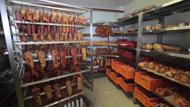 Sticks of salami or sausage suspended by ropes in the fridge. panorama