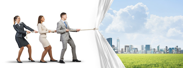 Young businesspeople working in collaboration and pulling white advertisement banner