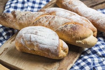 Assortment of baked bread on wooden table background