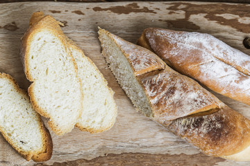 Assortment of baked bread on wooden table background