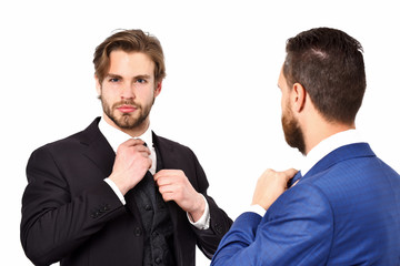 businessmen in blue and black suit tying the necktie
