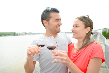 couple drinking wine by river