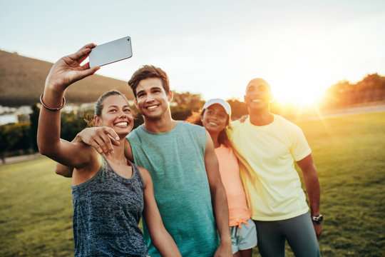 Young sporty woman taking a selfie with friends