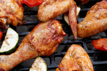Meat and vegetables during grilling. Assorted types of chicken