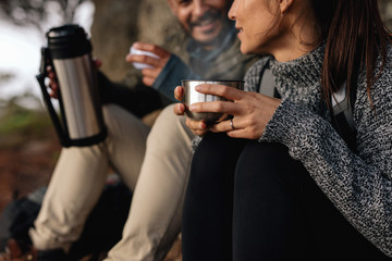 Couple hiking talking rest and drinking coffee