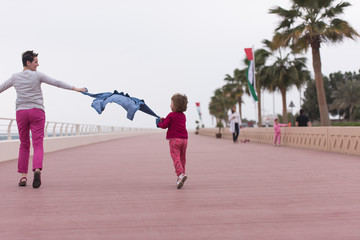 Fototapeta premium mother and cute little girl on the promenade by the sea