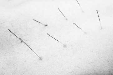 Chinese medicine doing acupuncture to man patient in silhouette studio.