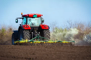 Tuinposter Tractor Farmer in tractor preparing land with seedbed cultivator