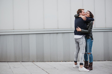 Couple having fun. Couple embracing. Friends giving each other a hug. Reunion. Farewell.