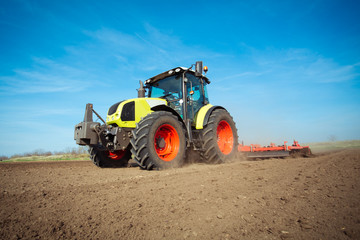 Farmer in tractor preparing land with seedbed cultivator