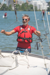 portrait of mature sportsman near catamaran