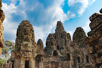Fototapeta na wymiar Prasat Bayon with smiling stone faces is the central temple of Angkor Thom Complex, Siem Reap, Cambodia. Ancient Khmer temple with frescoes and columns, World Heritage. Selective focus