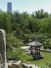 Peaceful park with Chinese pavilion and skyscraper in the distance, Beijing, China