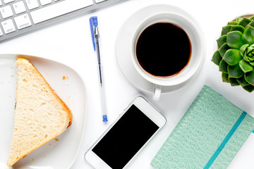 Office desk and breakfast with coffee and sandwich on white background top view