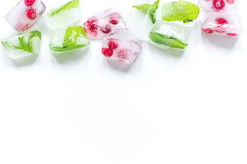 mint and red berries in ice cubes white background top view mockup