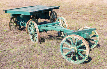 Fototapeta na wymiar Country life. Old wooden carts without a horses stand at the field