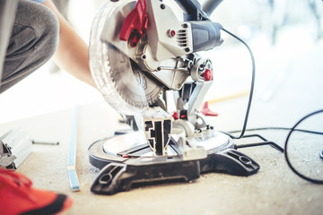 COnstruction worker cutting and sawing metal with circular grinder, mitre-saw